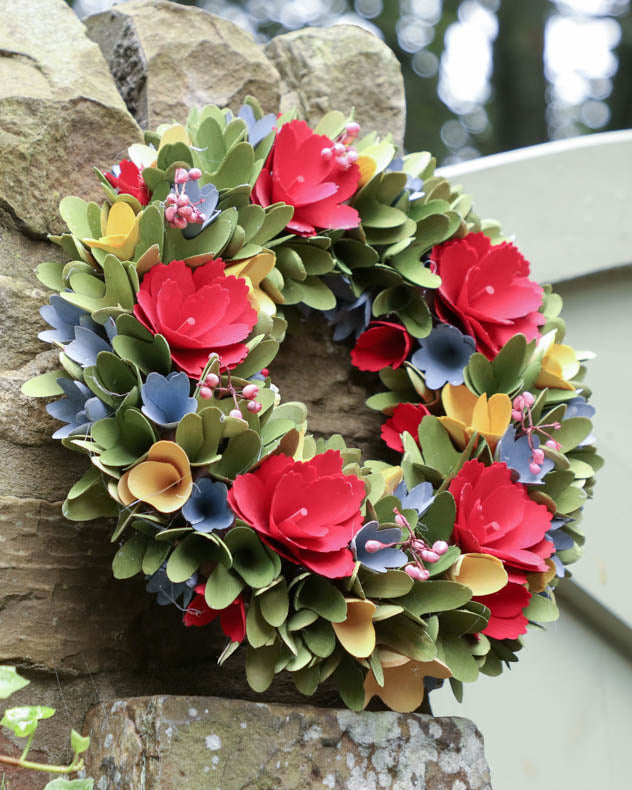 colourful wreath leaning against stone wall